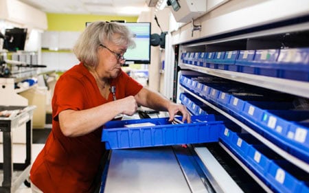 operator using vertical carousel in hospital pharmacy